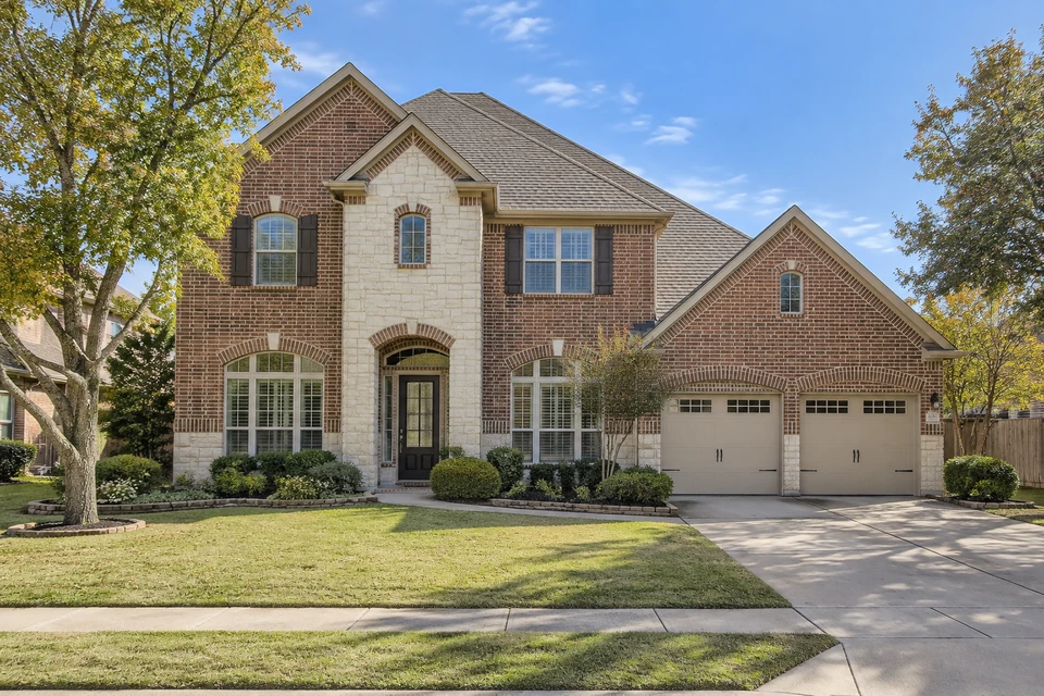 Illustrative brick home in daylight before holiday lighting