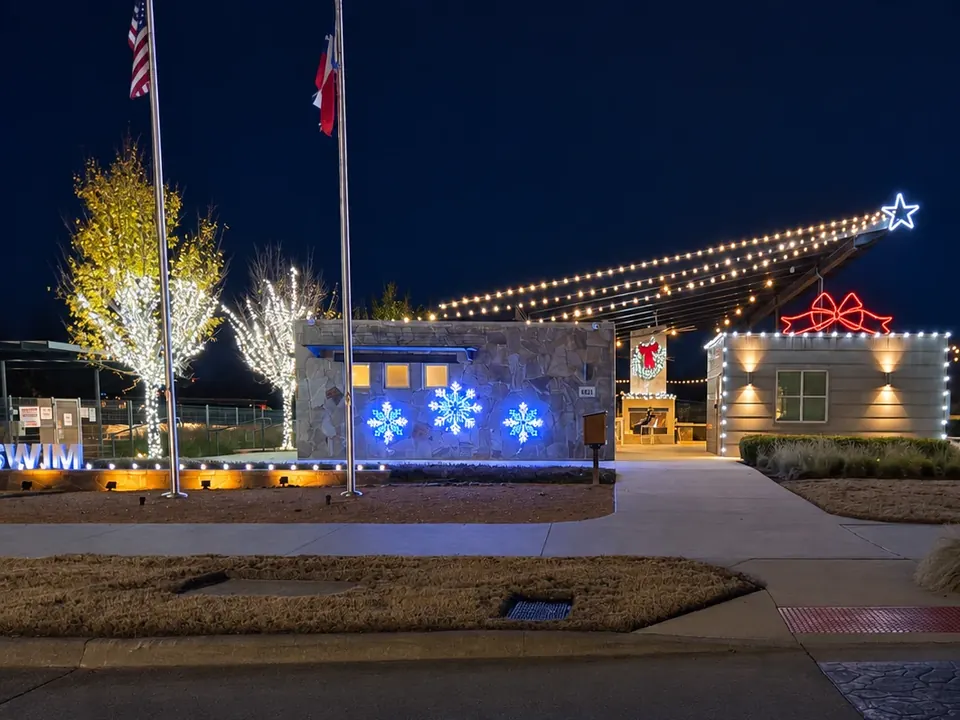 Christmas lights and illuminated snowflakes at a community pool and pavilion